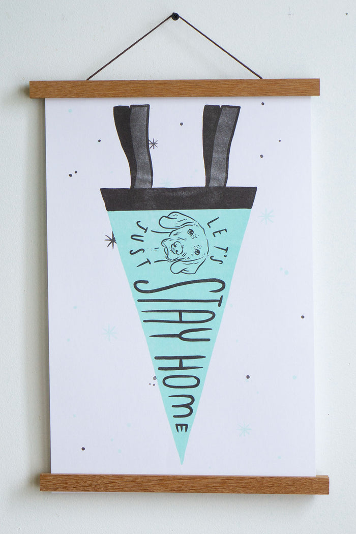 print of light blue pennant on white background with black trim and drawing of dog with the words let's just stay home inside